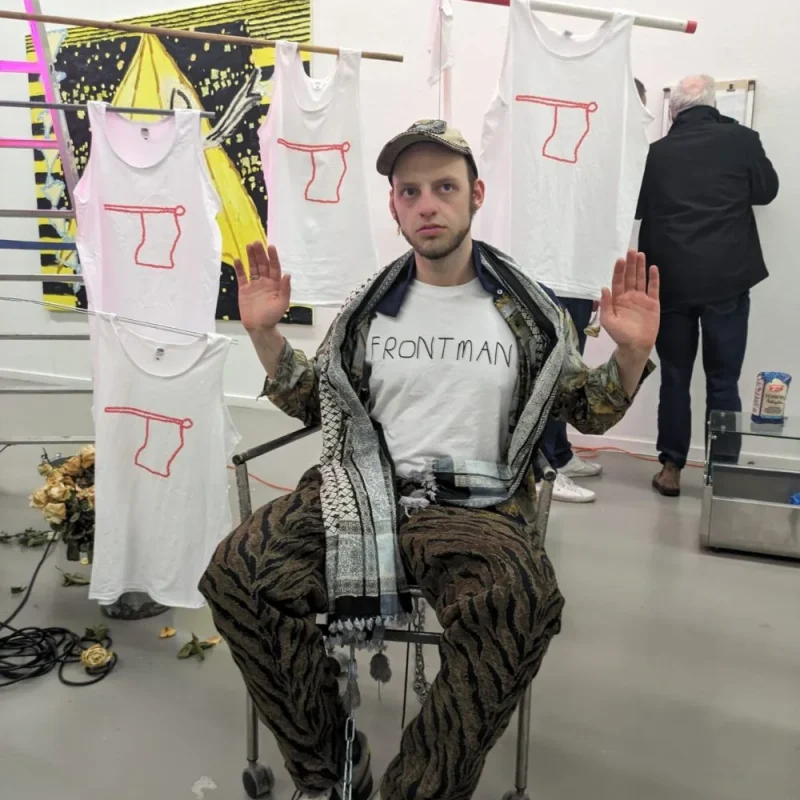 Portrait of the artist Jannes van Arkel among his printed shirts