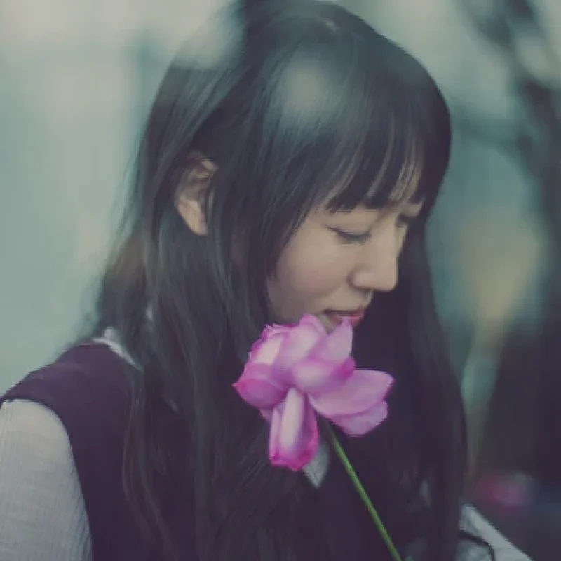 Portrait of the artist Ai Natori holding a pink flower